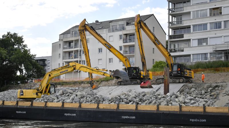 Michel Mohier, conducteur d’engins embarqué à bord du ponton, dépose les enrochements sur la berge, tandis que les deux pelles équipées de GPS, positionnent les roches pour que le talus prenne forme correctement. © Rodolphe Delaroque